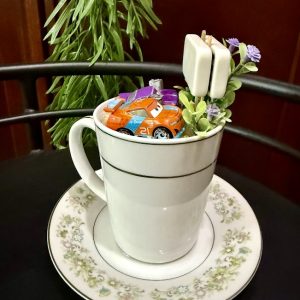 Cars-Teacup-Garden Toy racecar in a mug garden filled with sand, florals, and faux greenery.