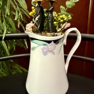 Samurai-Serenity-Pitcher-Garden Miniature samurai figures in a floral pitcher with greenery and flowers, creating a peaceful tabletop garden.